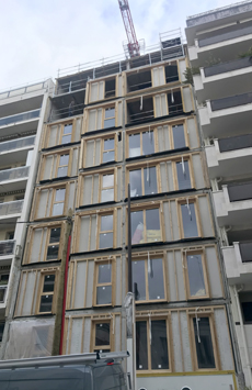 assemblage des parois bois préfabriquées fixées sur la structure porteuse en béton