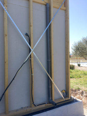 Détail de la fixation des feuillards sur l'ossature et détail de la base du mur